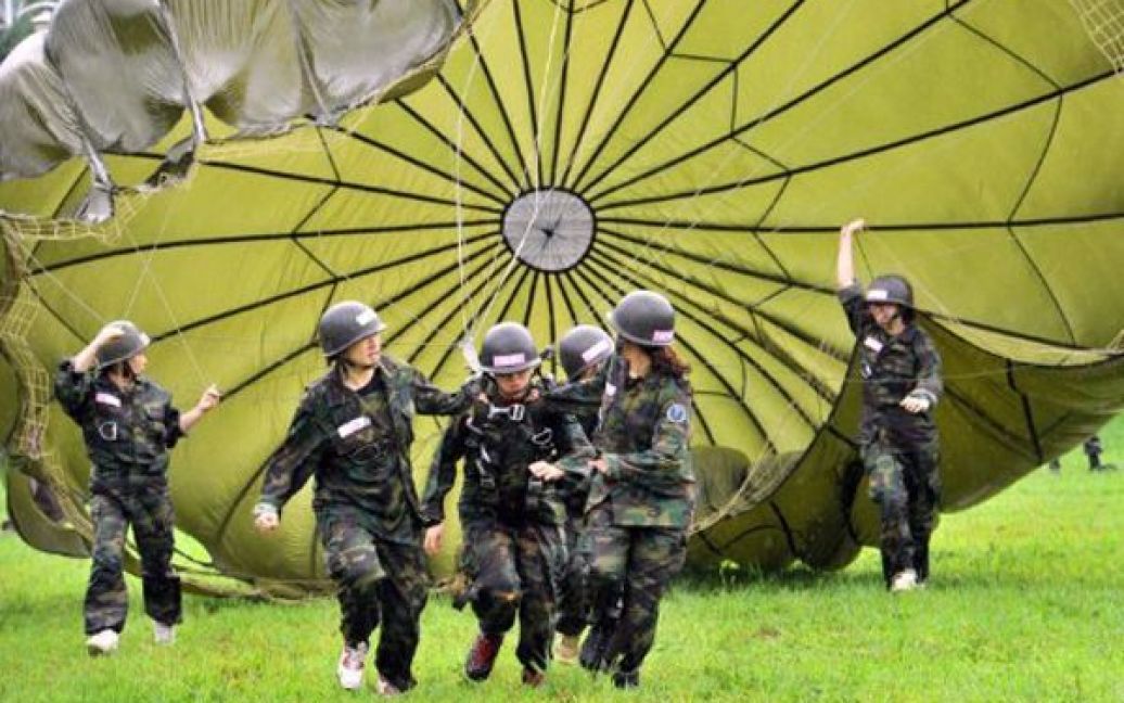 Республіка Корея, Сеул. Жінки тягнуть парашут під час занять у літньому військовому таборі для цивільного населення. У таборі взяли участь 1034 корейці, які зголосилися пройти крізь усі випробування військової підготовки. / © AFP