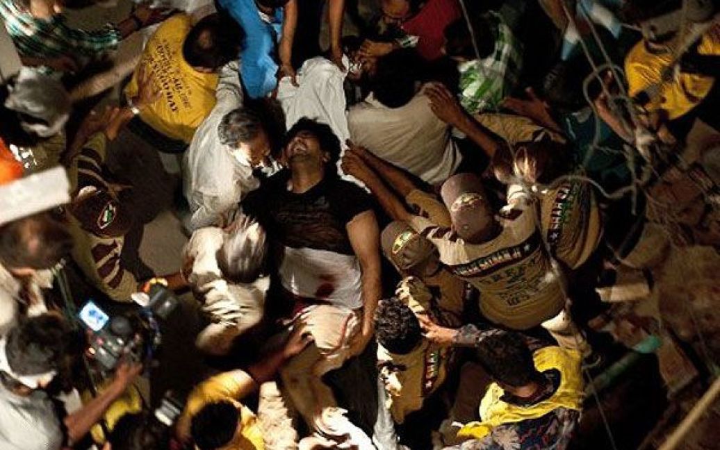 Індія, Нью-Делі. Чоловіка несуть до автомобіля швидкої допомоги, оскільки він отримав поранення під час обвалення будівлі в старих кварталах Нью-Делі. В результаті обвалу, постраждало не менше 18 осіб, 4 людини загинули. / © AFP