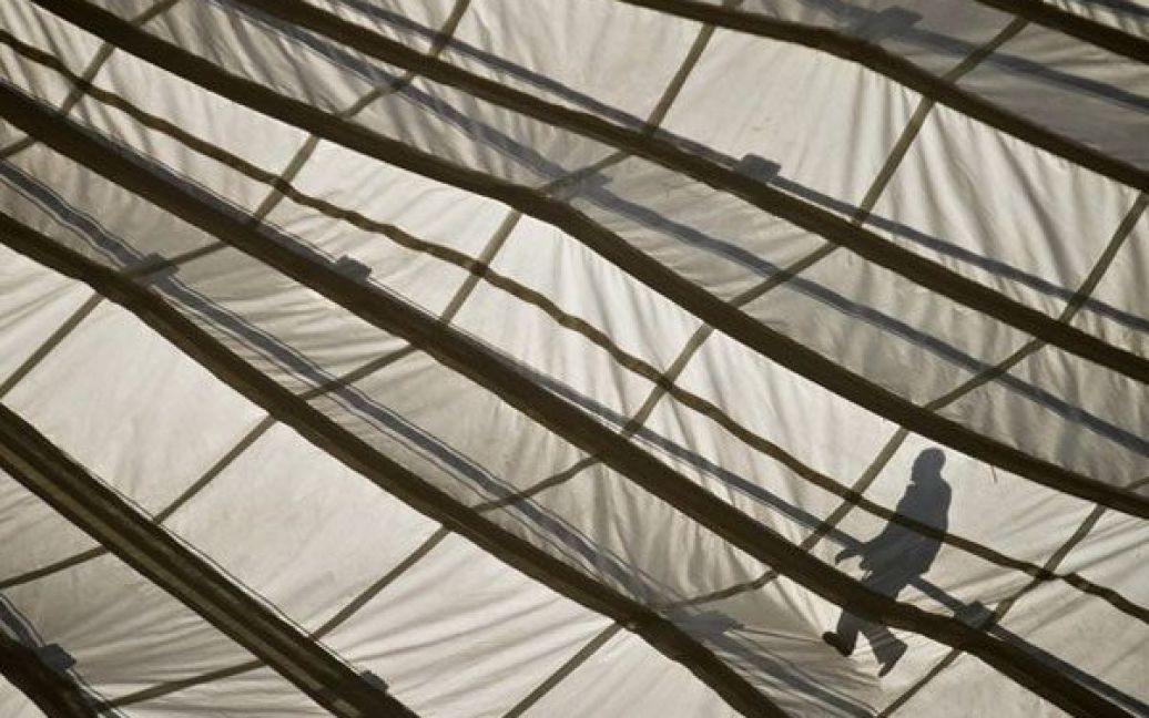 Польща, Варшава. Тінь працівника видно на даху Польського національного стадіону, на будівельному майданчику якого провели день відкритих дверей. / © AFP