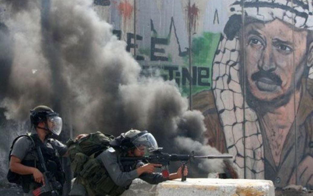 Каландія. Ізраїльські солдати утримують свої позиції під час зіткнень з палестинськими протестувальниками, які закидують камінням КПП Каландія між Рамаллою та Єрусалимом. / © AFP