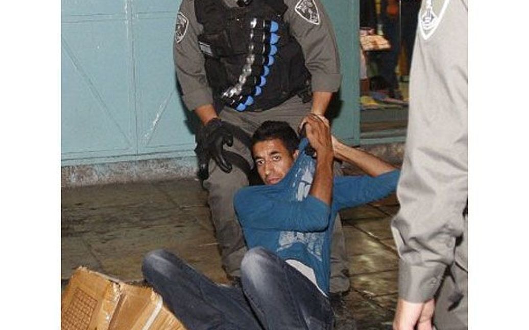 Єрусалим. Ізраїльський прикордонний поліцейський затримує палестинського демонстранта під час акції протесту в Єрусалимі проти триваючої військової операції Ізраїлю в Секторі Газа. / © AFP