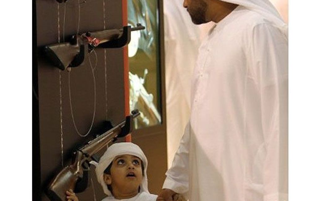 Об&#039;єднані Арабські Емірати, Абу-Дабі. Хлопчик з батьком відвідують 17-у міжнародну виставку товарів для полювання і коней в Абу-Дабі. / © AFP