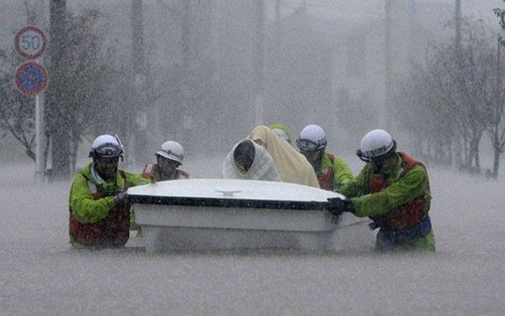Японія, Нагоя. Рятувальники транспортують у човні евакуйованих під час повені в місті Нагоя, префектура Аїті. Сотні тисяч людей по всій Японії попросили залишити їхні будинки через наближення тайфуна, який приніс проливні дощі і загрозу зсувів і паводків. / © AFP