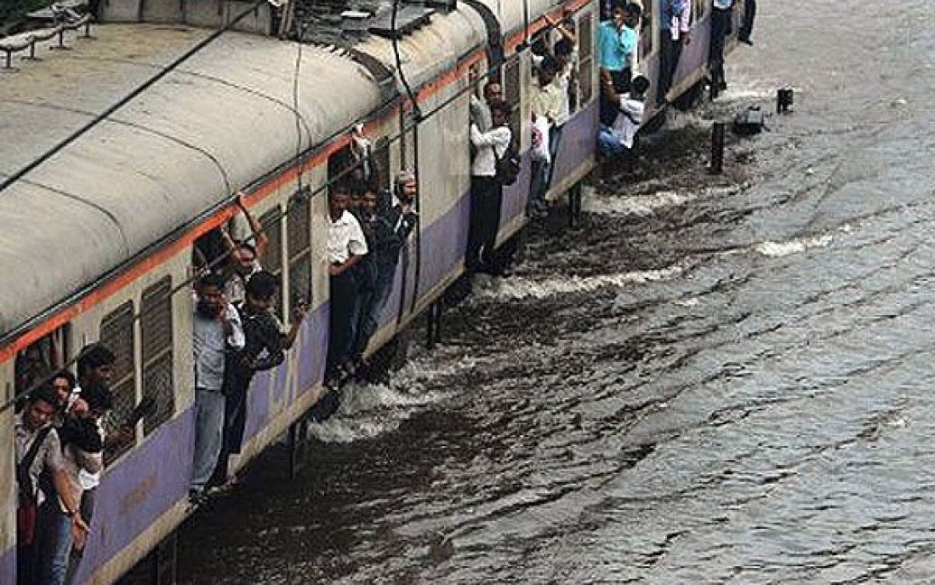 Індія, Мумбаї. Місцевий потяг проходить через залізничні шляхи, затоплені після потужних злив у Мумбаї. Через стихію в країні було порушено залізничний рух, а метеобюро прогнозує ще більші дощі. / © AFP