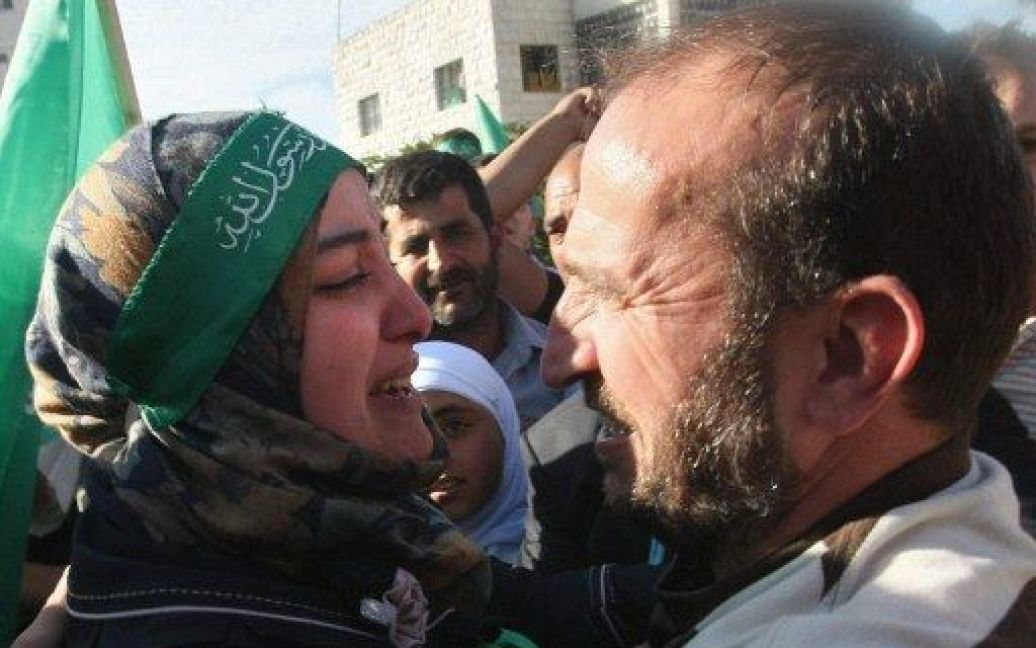 Хеврон. Палестинська жінка з хусткою руху ХАМАС на голові вітає свого брата, який повернувся з ізраїльського полону. В обмін на капрала Гілада Шаліта ізраїльська влада погодилась випустити більше тисячі палестинських в&rsquo;язнів. / © AFP