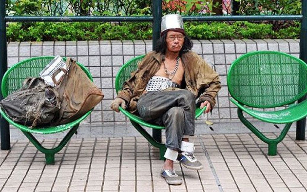 Китай, Гонконг. Безпритульний, одягнений у різні металеві предмети, сидить у міському парку Гонконгу. Рівень безробіття в Гонконзі досяг історичного максимуму (8,60%) у червні 2003 року, а рекордно низький рівень (1%) було зафіксовано у липні 1989 року. / © AFP