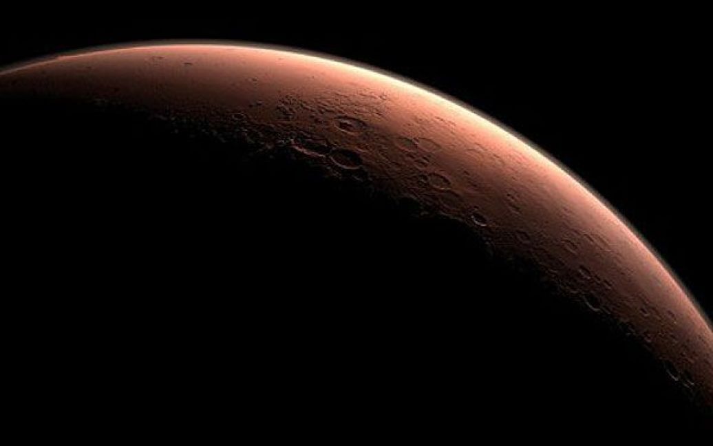 Космос. Частина Марса на кордоні між темрявою і світлом, включаючи кратер Гейла, у ранковому світлі. НАСА обрало кратер Гейла в якості посадкового майданчика для наукової дослідницької лабораторії "Mars Science Laboratory". Марсоход доставлять на Марс у серпні 2012 року. Фото AFP/NASA/JLP/Caltech / © AFP