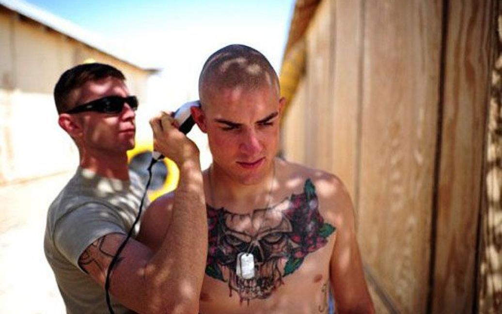 Афганістан, Кушамонд. Американський військовий допомагає своєму товаришу поголитися. Зі 100 тисяч американських солдат в Афганістані, 33 тисячі повернуться додому до середини 2012 року. / © AFP