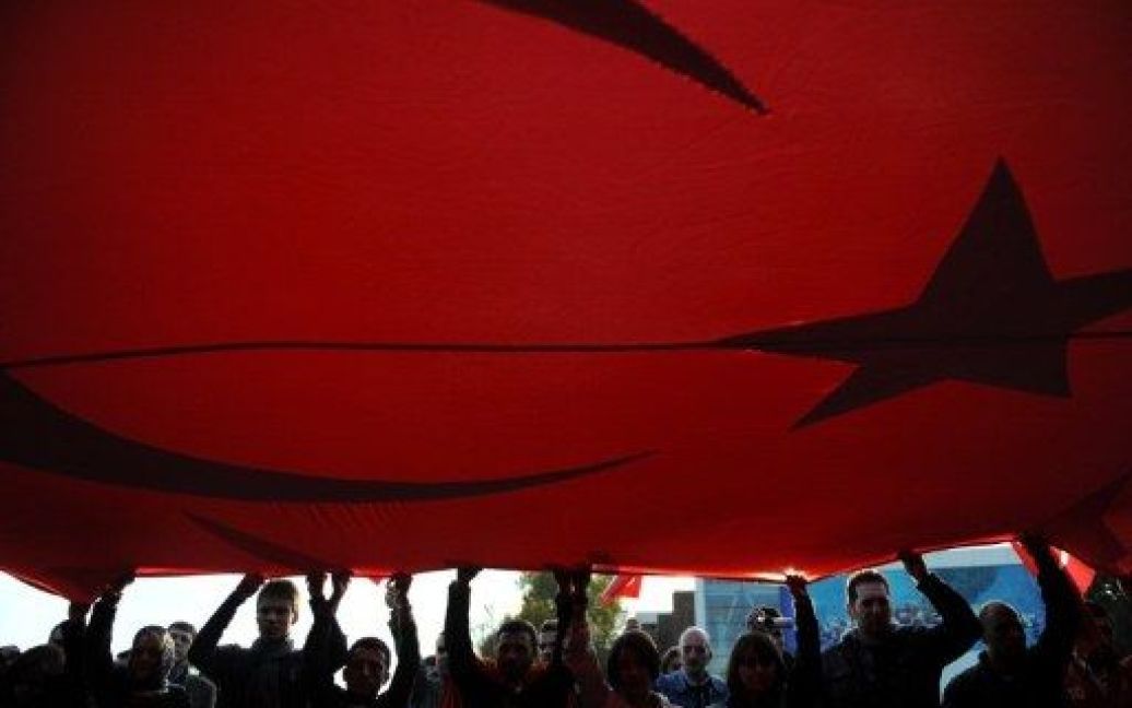 Туреччина, Стамбул. Демонстранти тримають гігантський турецький прапор під час акції протесту в центрі Стамбула. Курдські повстанці вбили 24 солдатів у нападах на південному сході Туреччини, відзначивши один з найстрашніших днів для армії у 27-річній боротьбі з сепаратистами. / © AFP