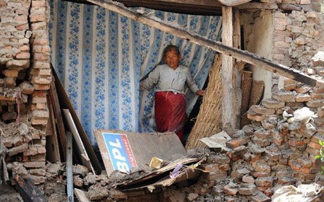 Непал, Катманду. Жінка визирає зі своєї квартири після того, як стіни її будинку завалилася під час землетрусу в Катманду. Щонайменше дев&rsquo;ятеро осіб в Непалі та Індії загинули в результаті 6,8-бального землетрусу з епіцентром в північно-східній Індії. / © AFP