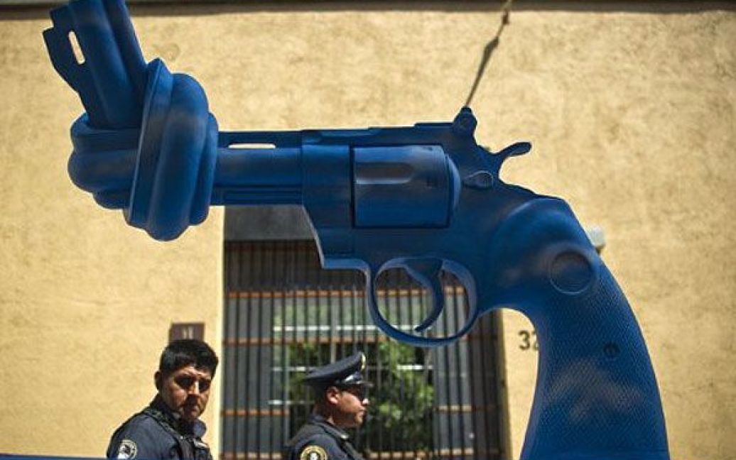 Мексика, Мехіко. Поліцейські роздивляються скульптуру у вигляді зав&rsquo;язаного на вузол пістолета в Мехіко. / © AFP