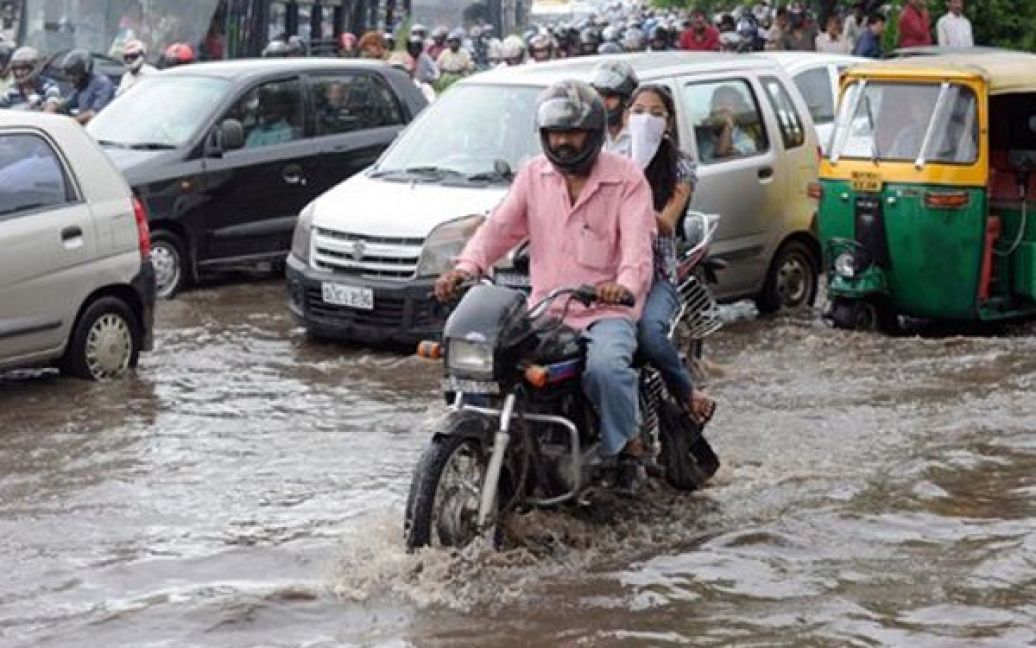 Індія, Делі. Люди намагаються проїхати по затопленим вулицям Делі. Внаслідок сильних злив частина районів індійської столиці опинилася під водою. / © AFP