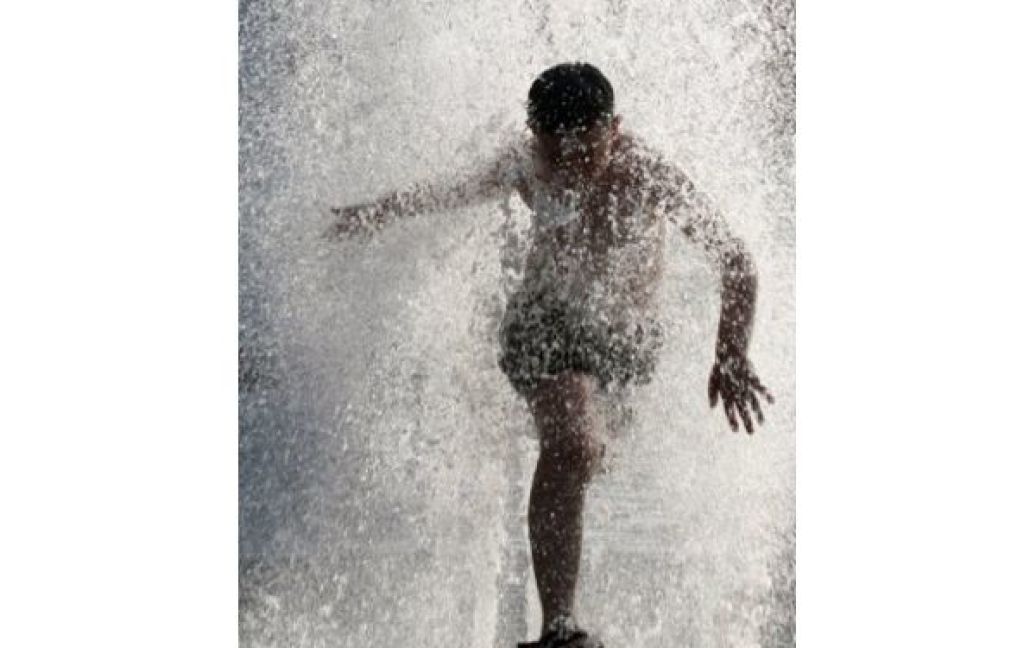 Грузія, Тбілісі. Хлопчик купається у фонтані у центрі Тбілісі. Температура повітря у Грузії сягнула 40 градусів Цельсія. / © AFP