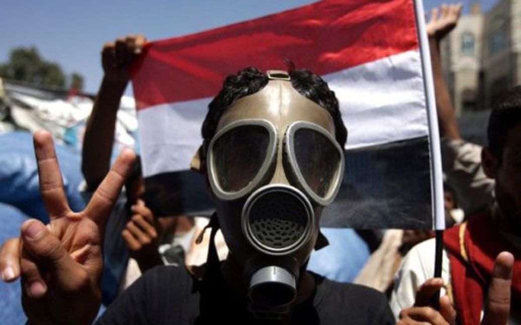 Ємен, Сана. Єменський опозиційний демонстрант у протигазі показує знак перемоги під час антиурядових протестів у Сані. / © AFP