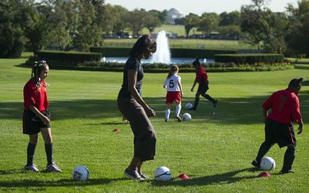 США, Вашингтон. Перша леді Мішель Обама грає у футбол під час проведення занять з дітьми в рамках програми "Давайте рухатись!" на Південній галявині Білого дому. / © AFP
