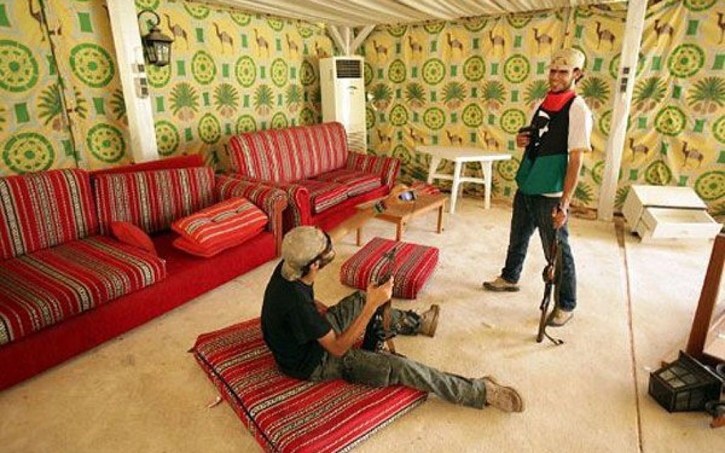 Лівійська Арабська Джамахірія, Тріполі. Лівійські повстанці фотографуються в наметі у резиденції Муаммара Каддафі, де лівійський лідер проводив зустрічі з високими зарубіжними гостями у Тріполі. Повстанці заявляють про повний контроль над лівійською столицею. / © AFP