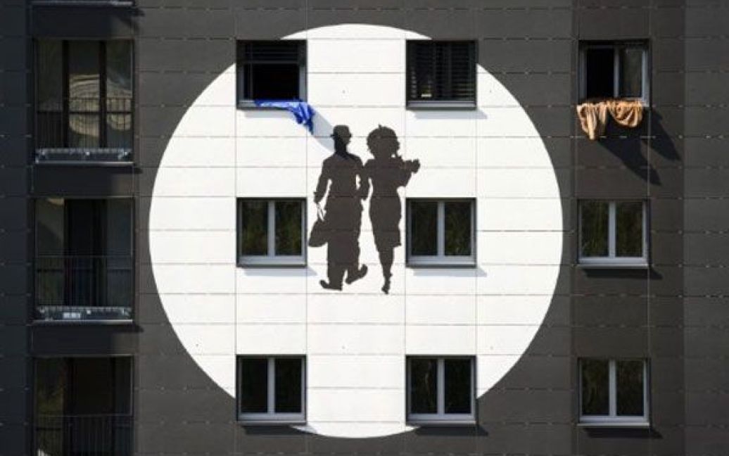 Швейцарія, Веве. Гігантське зображення англійського коміка, режисера і композитора Чарлі Чапліна показують на екрані, встановленому на 40-метрових вежах Gilament у місті Веве. / © AFP