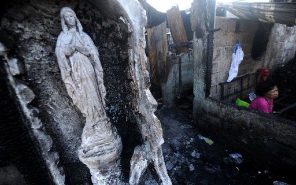 Філіппіни, Маніла. Людина шукає вцілілі речі у будинку, який постраждав під час нічної пожежі у нетрях Кесон-Сіті в Манілі. Майже 70 будинків згоріли, інформації про жертви не надходило. / © AFP