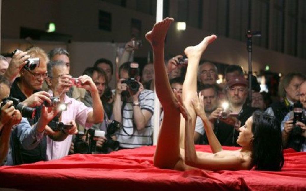 Німеччина, Берлін. Гола жінка позує чоловікам на міжнародній еротичній виставці Venus, яка проходить в Берліні. Організатори очікують, що цього року виставку відвідають більше 30 тисяч споживачів. / © AFP