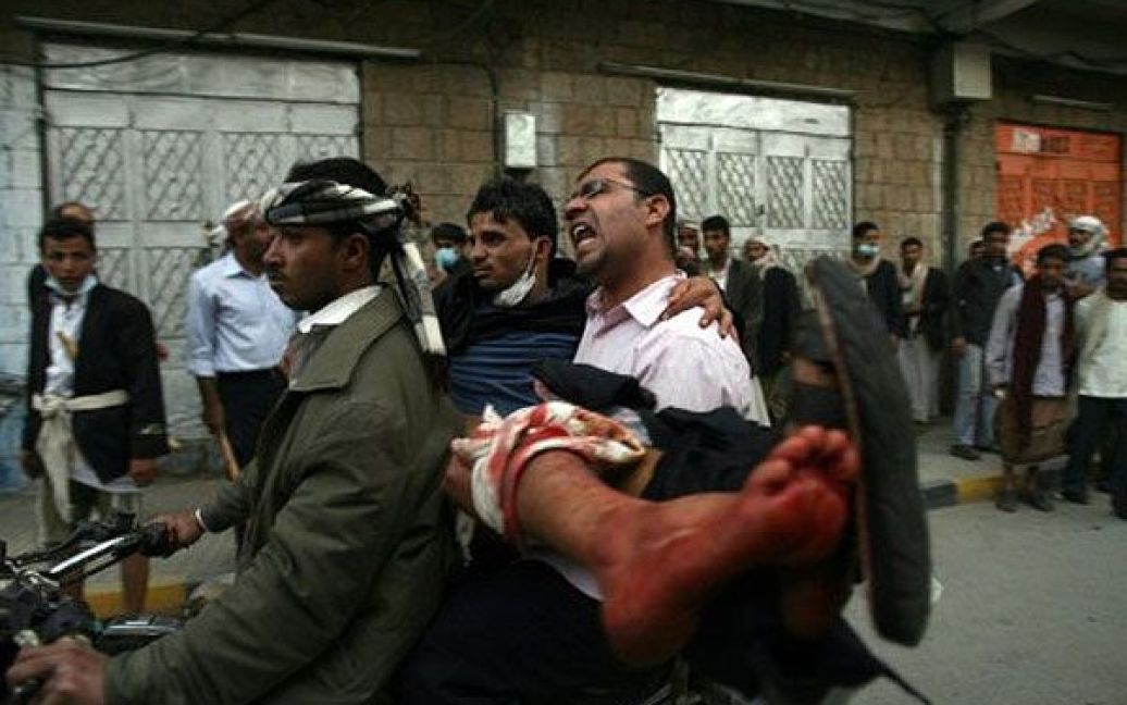 Ємен, Сана. Єменського пікетувальника, який отримав поранення у зіткненнях з урядовими військами під час антиурядової демонстрації за межами університету Сани, доставляють до лікарні на мотоциклі. Демонстранти закликали до відставки президента країни Алі Абдалли Салеха. / © AFP