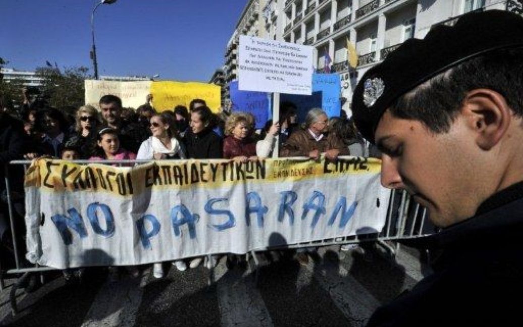 Греція, Афіни. Учасники акції протесту проти жорсткої економії тримають прапор під час студентського маршу в Афінах. / © AFP