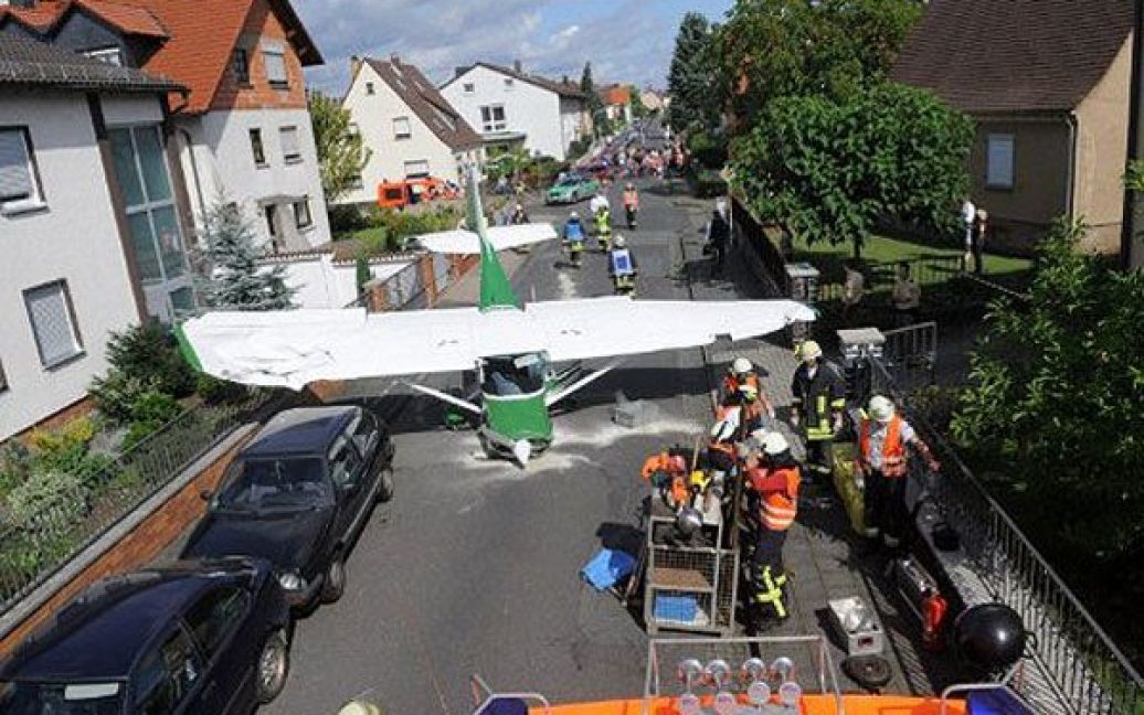 Німеччина, Стокштадт. Аварійні служби працюють на місці падіння легкого літака, який врізався у житловий будинок в центральному німецькому місті Стокштадт. Під час аварії двоє людей отримали поранення. / © AFP