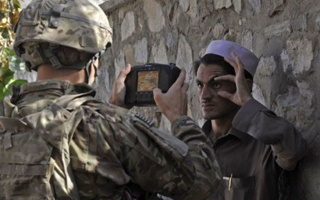 Афганістан, Турхам. Американський солдат Алекс Лоутон сканує очі афганця для внесення інформації до автоматизованої системи біометричної ідентифікації. / © AFP