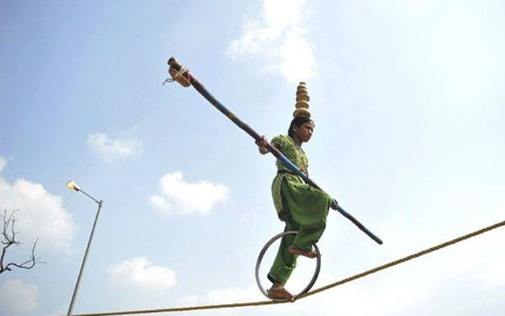 Індія, Нью-Делі. Індійський вуличний артист виступає на мотузці у старій частині Нью-Делі. / © AFP