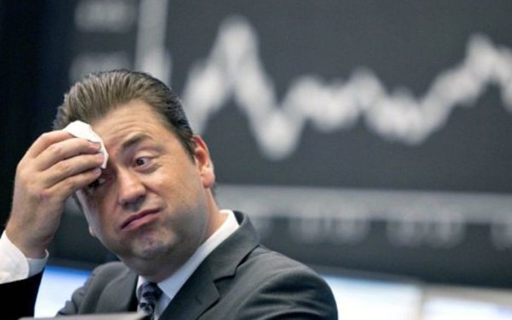 Німеччина, Франкфурт. Трейдер витирає піт з чола у приміщенні Франкфуртської біржі. Німецький фондовий індекс DAX втратив 2,37 пункти на момент закінчення ранкових торгів. / © AFP