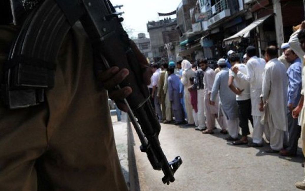 Пакистан, Лахор. Поліцейський охороняє чергу до мечеті. У Пакистані, другій за численністю мусульманській країні світу, Рамадан почався на день пізніше, оскільки місцеві мулли не підтвердили появу молодого місяця. / © AFP