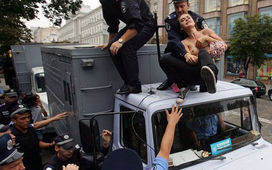 Співробітники міліції знімають активісток FEMEN з даху автозака. / © УНІАН