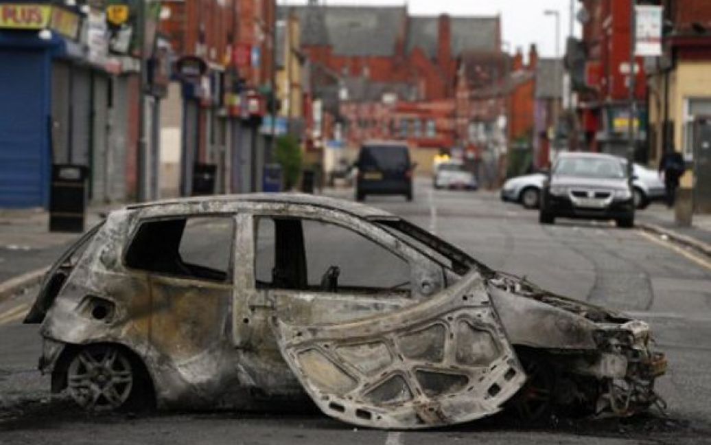 Великобританія, Ліверпуль. Спалений автомобіль на вулиці Ліверпуля, куди учора перекинулися заворушення. Вчора до Лондона було перекинуто 16 тисяч поліцейських, і ніч видалася порівняно спокійною. / © 