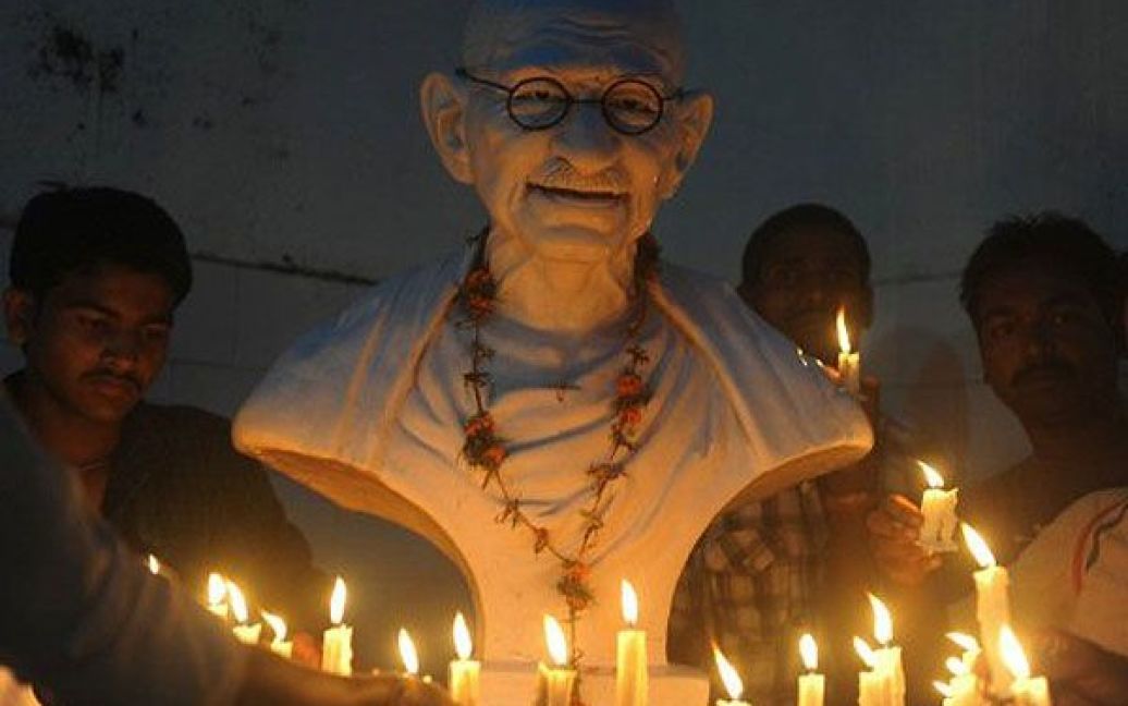 Індія, Сілігурі. Індійські прихильники громадського діяча Анни Хазаре встановили свічки перед бюстом Махатми Ганді під час мітингу на підтримку Хазаре. / © AFP