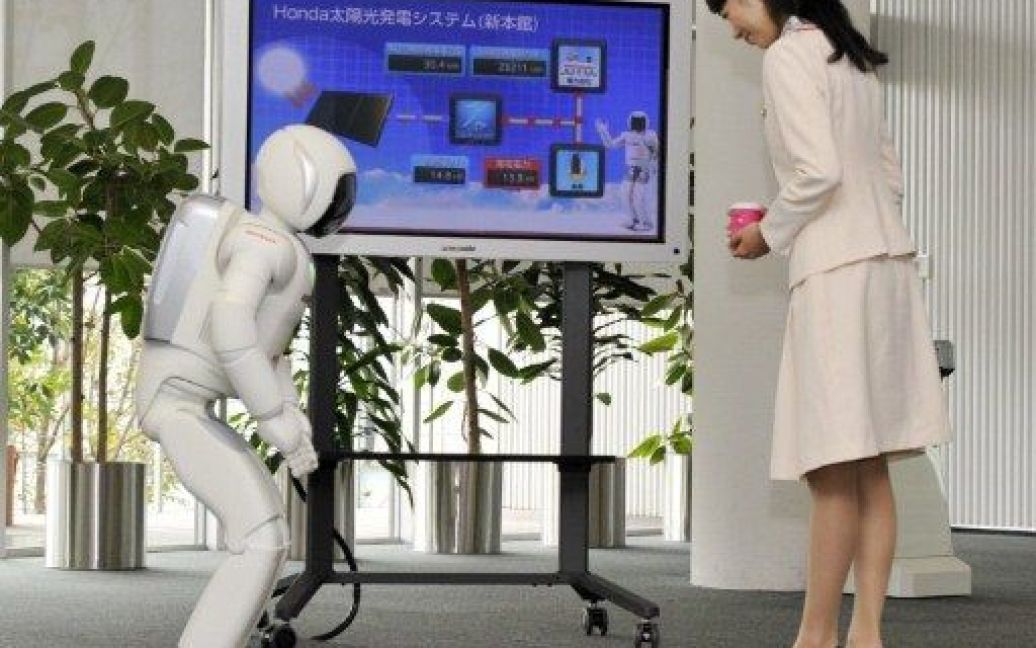Японія, Вако. Співробітник компанії Honda представляє людиноподібного робота Asimo, який може виконувати нові численні функції. Зокрема, робот Asimo може рухатися без контролю з боку оператора. / © AFP