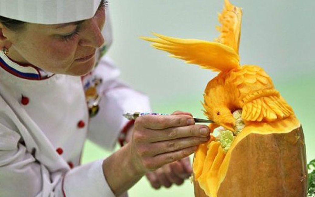 Німеччина, Лейпциг. Російський рослинний різьбяр Анастасія Корсакова завершує роботу над скульптурою під час участі у першому європейському конкурсі з різьби на рослинах. Учасники конкурс мають чотири години, щоб вирізати на очах у журі скульптуру з дині, папайї, капусти, огірка, редису, моркви або китайської капусти. / © AFP