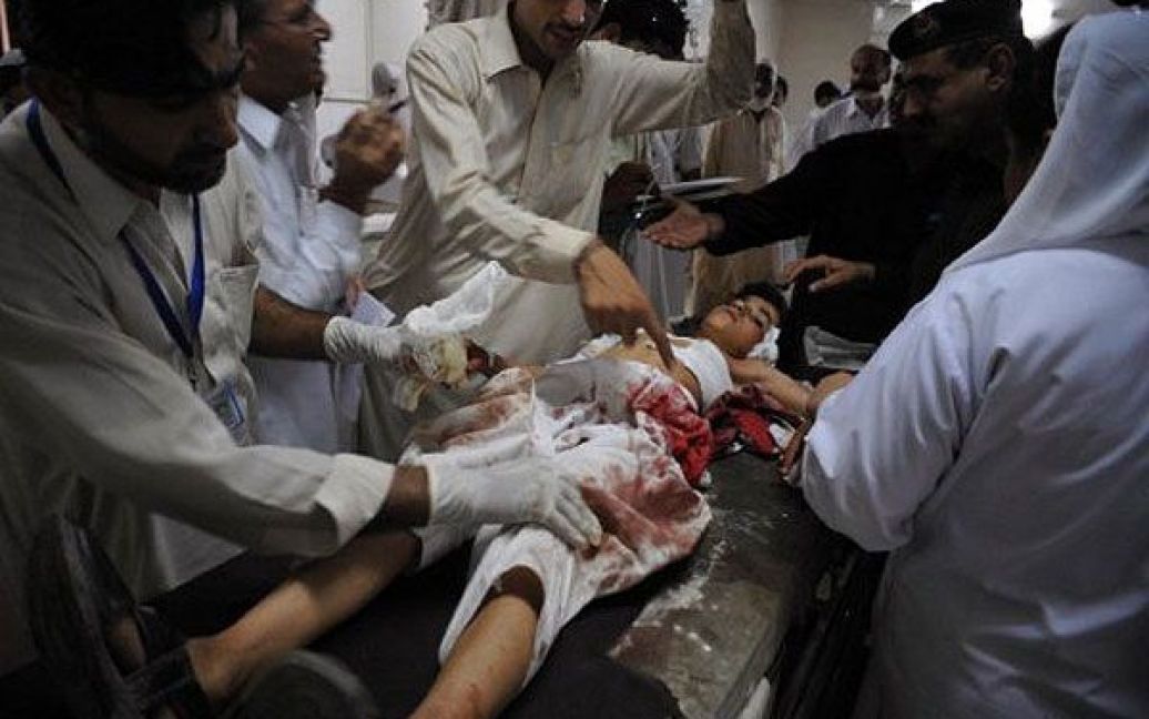 Пакистан, Пешавар. Пакистанські фельдшери допомагають студенту, який отримав поранення після нападу бойовиків в Пешаварі. Бойовики влаштували засідку на шкільний автобус, в результаті ракетного обстрілу загинули четверо дітей і водій. / © AFP