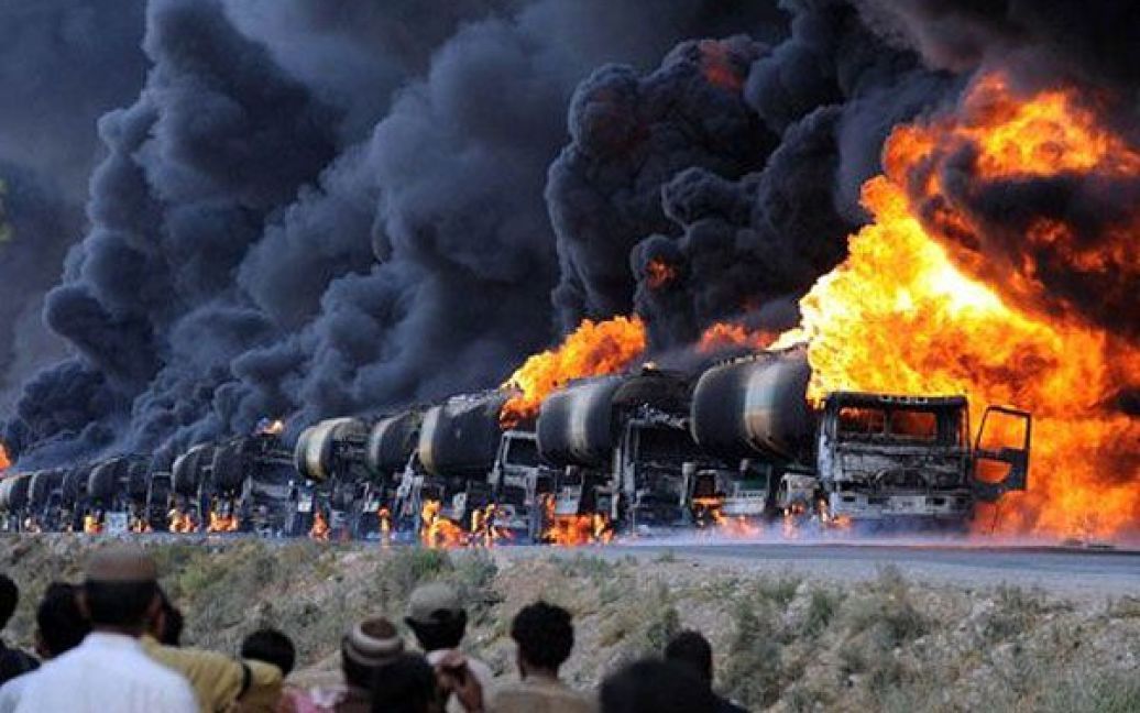 Пакистан, Кольпур. Місцеві жителі дивляться на нафтові танкери НАТО, підпалені бойовиками на головному шосе поблизу міста Кветта у неспокійній провінції Белуджистан. / © AFP