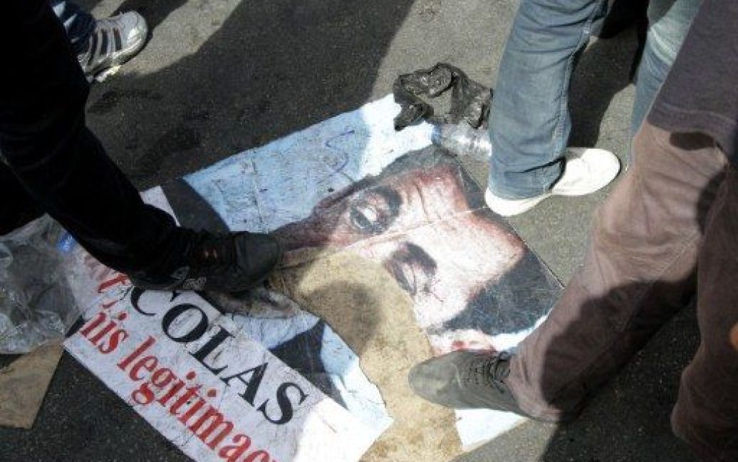 Сирія, Дамаск. Прихильники президента Сирії Башара аль-Асада проходять по розірваному портрету президента Франції Ніколя Саркозі під час масового провладного мітингу в Дамаску. / © AFP