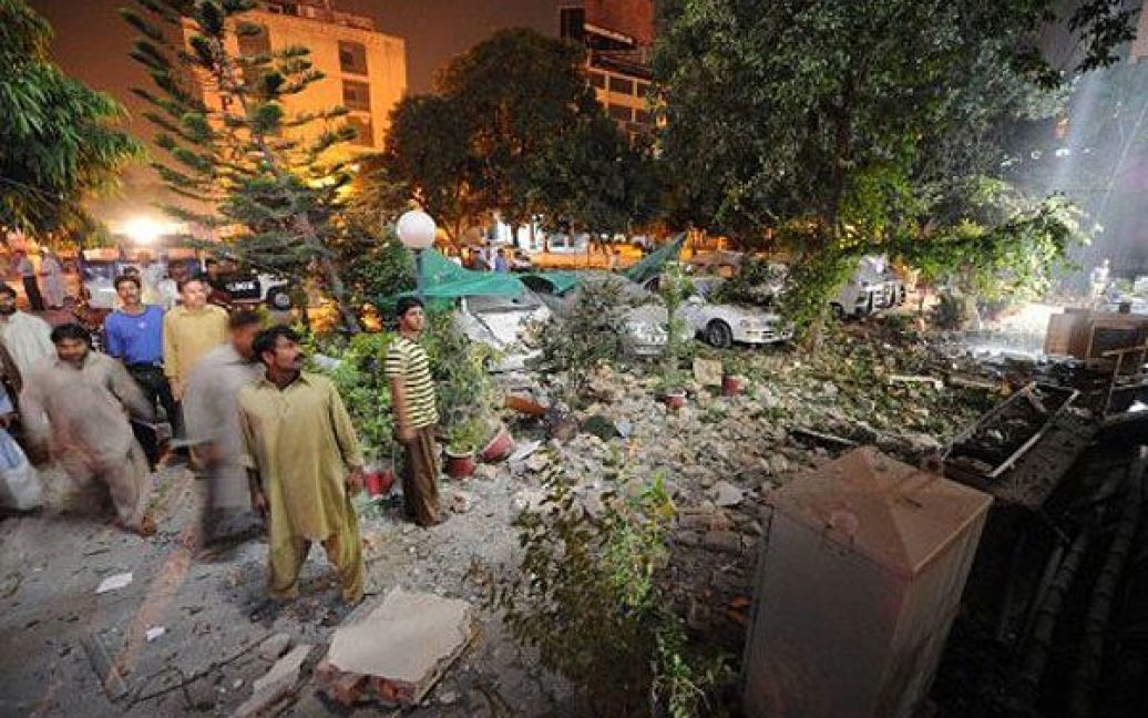Пакистан, Ісламабад. Місцеві жителі збираються на місці вибуху, яким було зруйновано верхні поверхи готелю в Ісламабаді. Щонайменше шестеро людей отримали поранення. Причиною інциденту став вибух газового балону. / © AFP