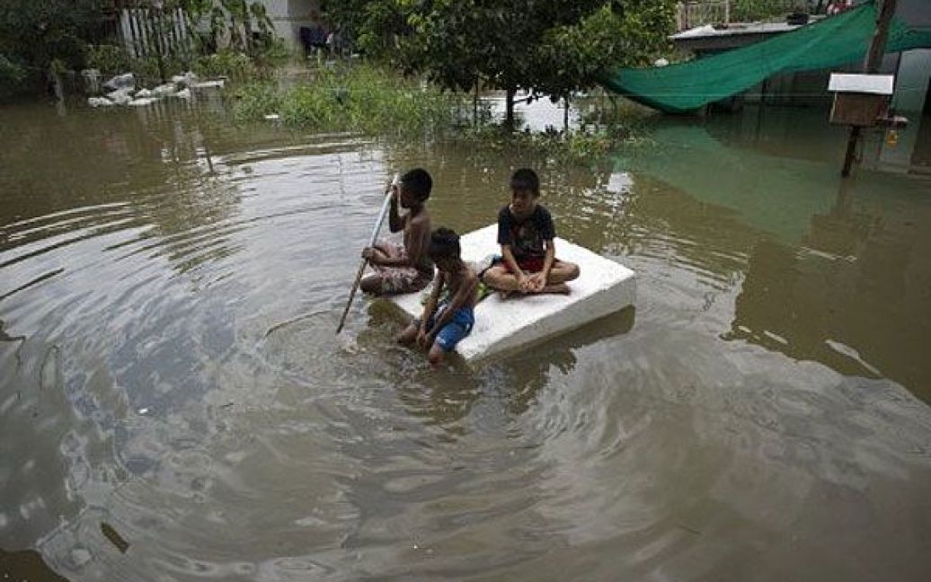 Таїланд, Аюттхая. Діти пливуть затопленими вулицями міста Аюттхая. В результаті повені у Таїланді, 70 осіб загинули, більше 4 мільйонів людей залишились без будинків та засобів до існування. / © AFP