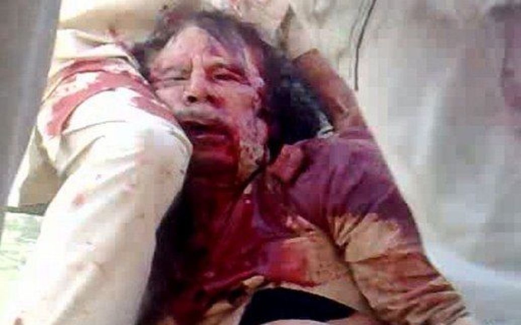 Телеканал "Аль-Джазіра" показав шокуючий відеозапис, на якому прихильники ПНР Лівії тягнуть напівоголене тіло Муамара Каддафі по вулиці / © AFP