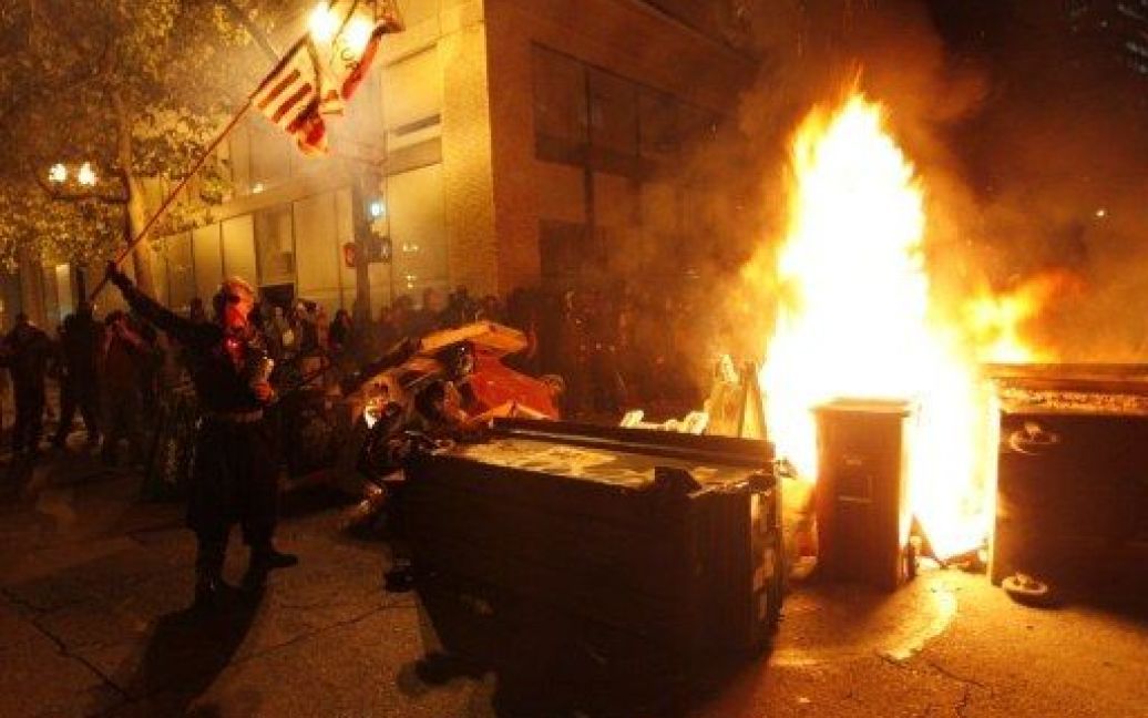 США, Окленд. Учасники акції протесту "Окупуй!.." підпалили баки зі сміттям і зробили барикаду на вулиці, доки поліція вишукувалась, щоб розігнати протестуючих. / © AFP
