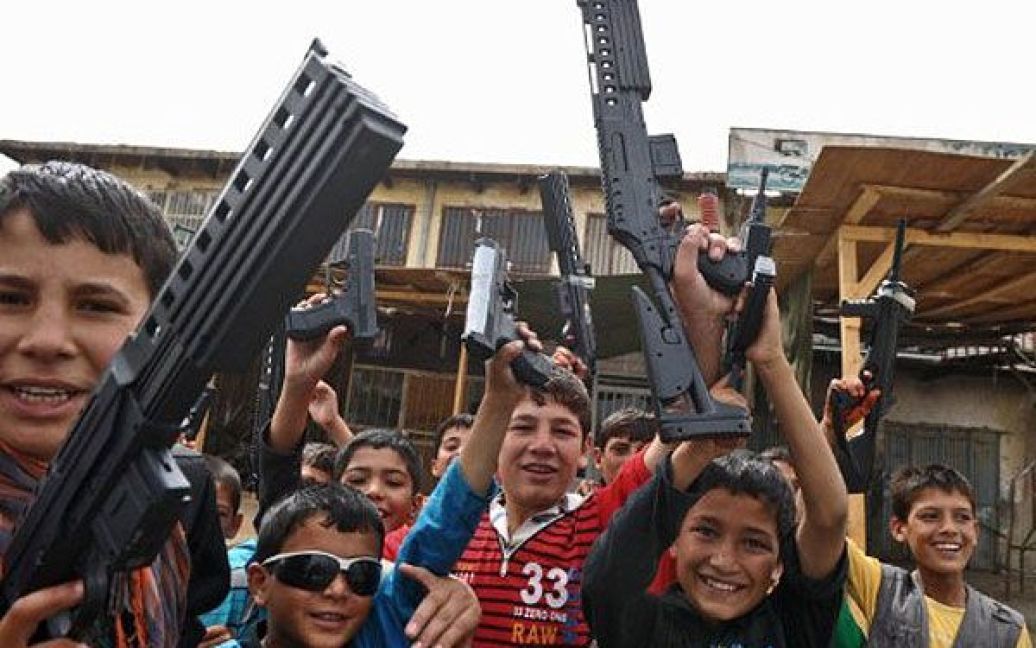 Афганістан, Баграм. Афганські діти грають з пластмасовою зброєю під час святкування свята Ід Аль-Фітр у провінції Парван. Тридення свято Ід Аль-Фітр знаменує закінчення священного місяця посту Рамадан. / © AFP