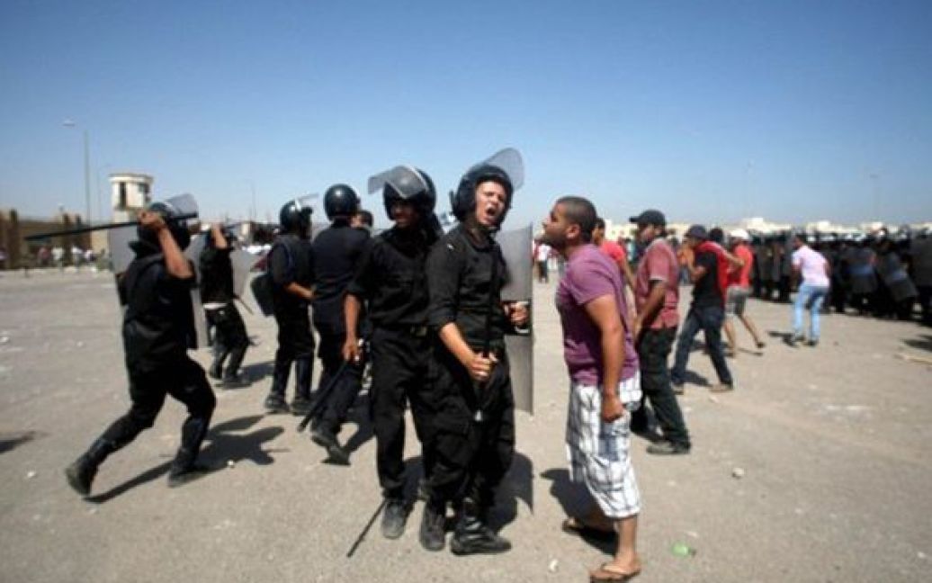 Єгипет, Каїр. Демонстрант сперечається з поліцейським під час акції протесту. У середу у Каїрі розпочалися слухання у справах проти екс-президента Єгипту, його синів та колишнього керівництва МВС, яких звинувачують у придушенні повстань після президентських виборів. / © AFP