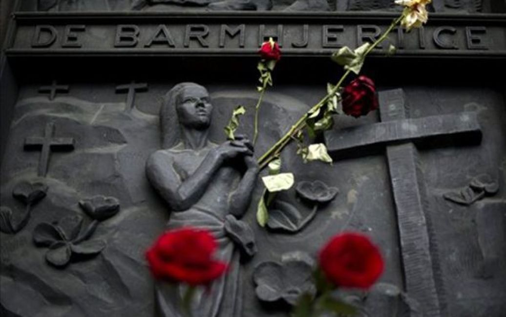Норвегія, Осло. Квіти лежать біля входу до собору, на дверях якого написано "Милосердний". Квіти приносили жителі Осло в пам&#039;ять про жертв терактів 22 липня. / © AFP