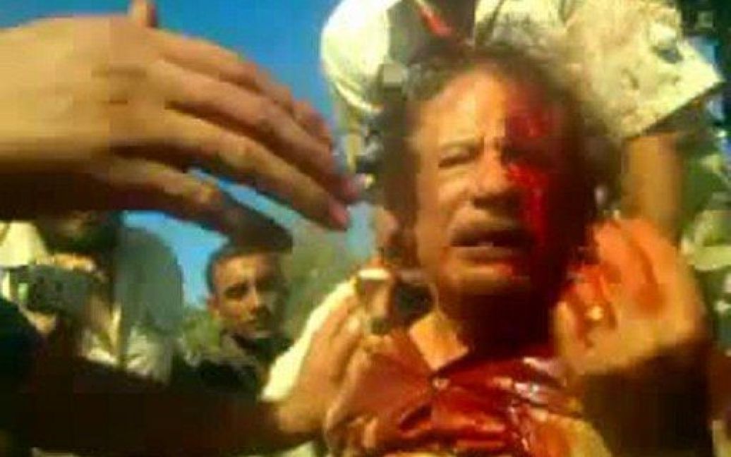 Лівійська Арабська Джамахірія, Сірт. Кадр з відео, знятого на мобільний телефон. Бойовики Національної перехідної ради оточили захопленого екс-лідера країни Муаммара Каддафі під час штурму міста Сірт. Каддафі був убитий 20 жовтня під час останнього штурму його рідного міста повстанськими силами. / © AFP