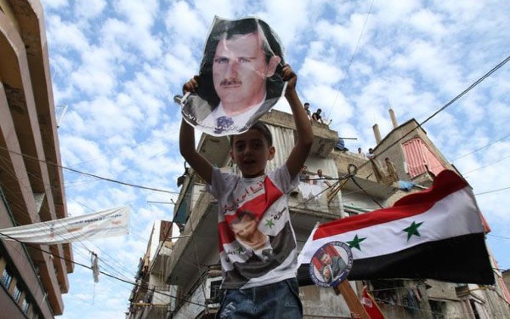Ліван, Бейрут. Юний прихильник режиму несе фотографію президента країни Башара аль-Асада під час акції протесту в Бейруті. Сирійські опозиційні рухи оголосили про створення "історичного" єдиного фронту проти режиму президента. / © AFP