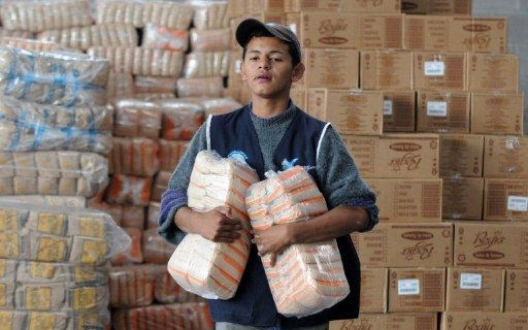 Гондурас, Тегусігальпа. Члени цивільної оборони готують пакунки з харчами до роздачі постраждалим від повеней і зсувів у південній частині країни. Принаймні, 80 осіб загинули, більше 100 тисяч людей постраждали в результаті проливних дощів. / © AFP