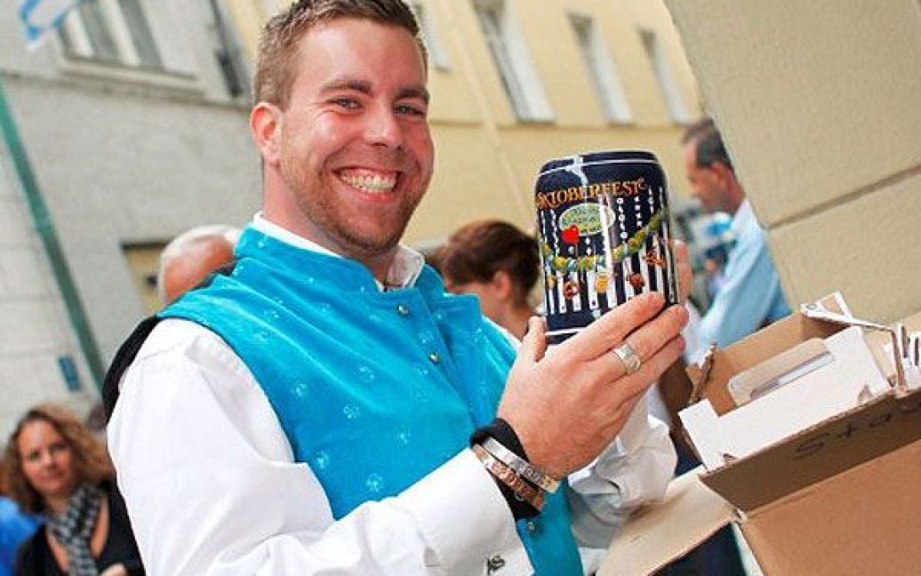 Німеччина, Мюнхен. Син головного шинкаря найбільшого у світі пивного фестивалю "Октоберфест" Олександр Schiebl посміхається, тримаючи нові кухлі для пива, які цього року презентують на всесвітньо відомому фестивалі пива. "Октоберфест-2011" у Мюнхені пройде з 17 вересня по 3 жовтня 2011 року. / © AFP