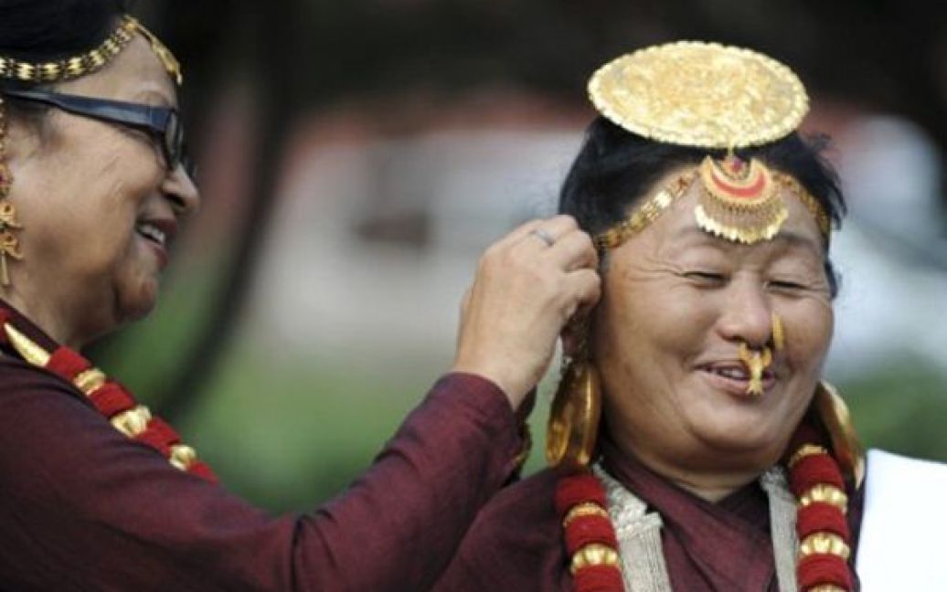 Непал, Катманду. Жінки допомагають одна одній одягнути національні прикраси перед початком параду з нагоди Дня корінних народів. / © AFP